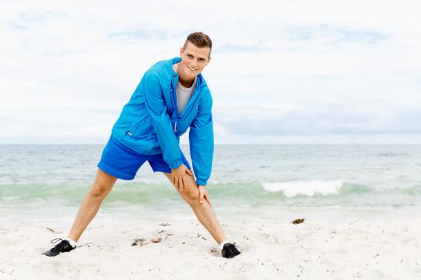 Man training on beach outside - Foto, imagen