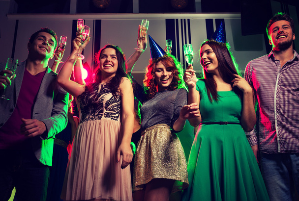 amigos sonrientes con copas de champán en el club
 - Foto, Imagen