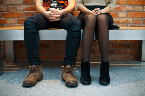 Fashionable stylish couple sitting on the bench. Legs close-up - Zdjęcie, obraz