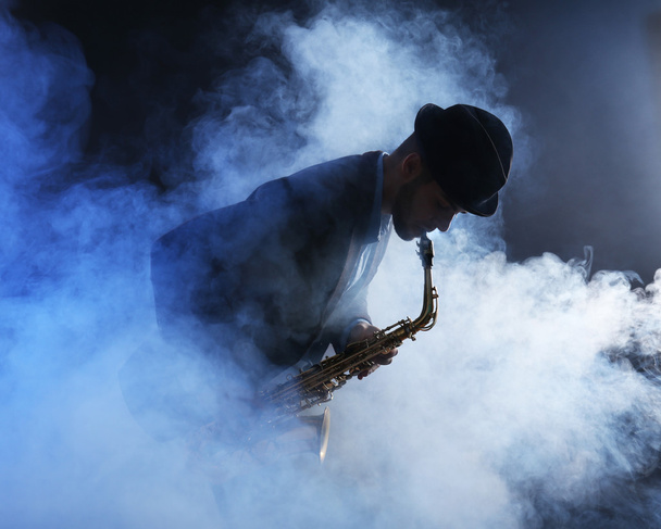 Young man playing on saxophone  - Fotó, kép