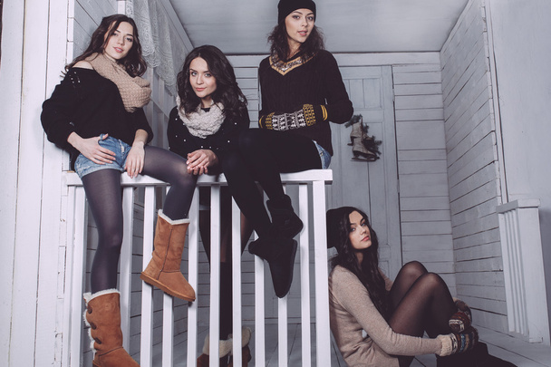 Four stylish models posing sitting on the fence - Photo, Image