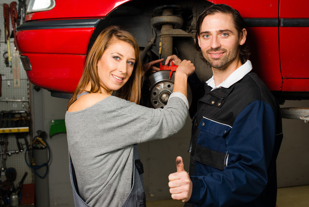 Auto mechanic and female trainee in garage - Photo, Image