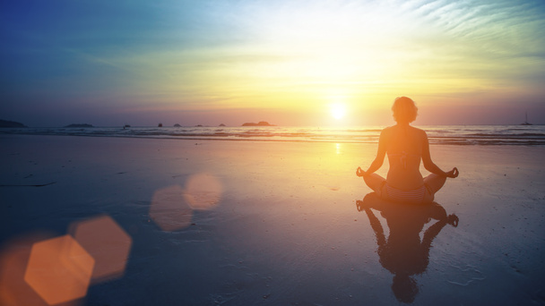femme en pose de yoga sur la plage - Photo, image