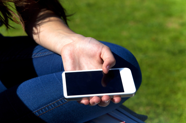 Hand holding a smartphone outdoors - Foto, Imagem