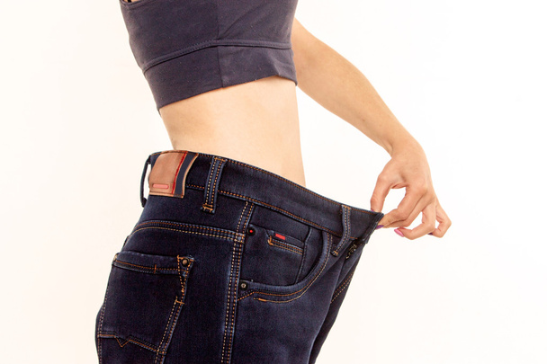  woman in old jeans pant after losing weight.  - Photo, Image
