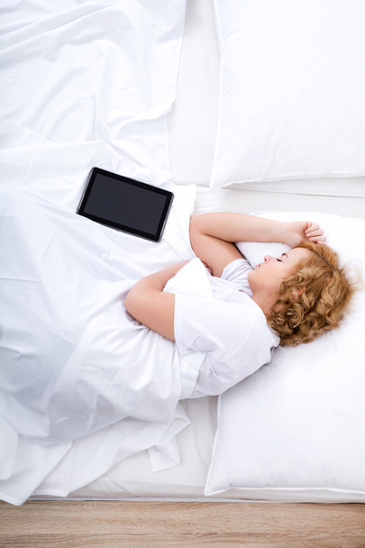 Young woman sleeping in Bed with a Tablet PC - Фото, изображение