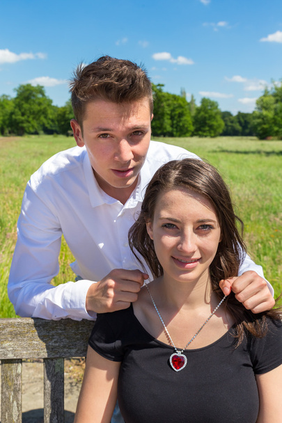 Ember szívét nyakláncot adva a fiatal, vonzó nő  - Fotó, kép