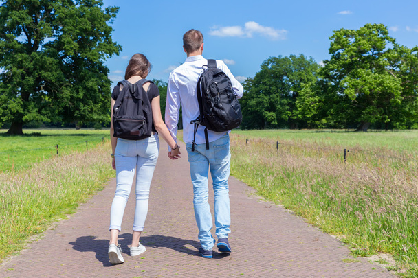 Jovem casal andando de mãos dadas na natureza
 - Foto, Imagem