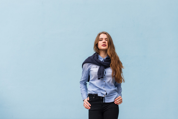 Beautiful girl on a background of blue wall - Foto, afbeelding
