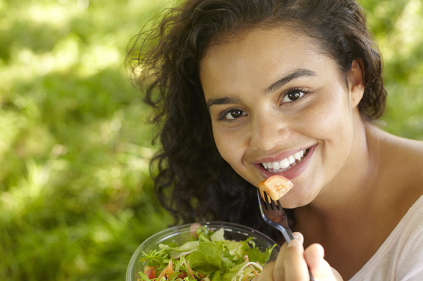 Mujer joven comiendo ensalada saludable al aire libre
 - Foto, Imagen