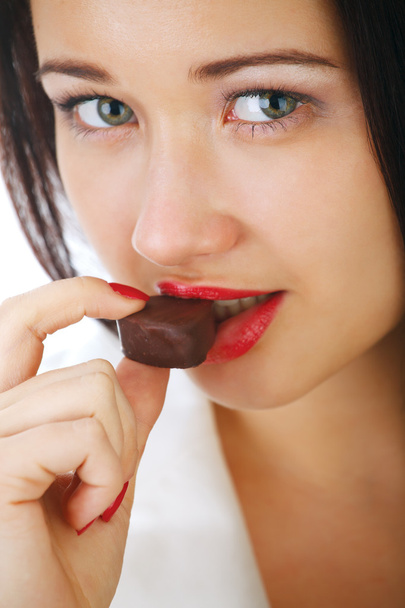 Beautiful girl with a chocolate candy. - Foto, afbeelding