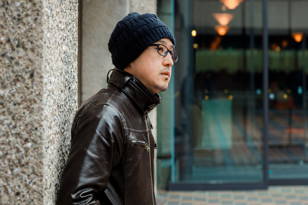 Um homem asiático em uma jaqueta marrom
  - Foto, Imagem