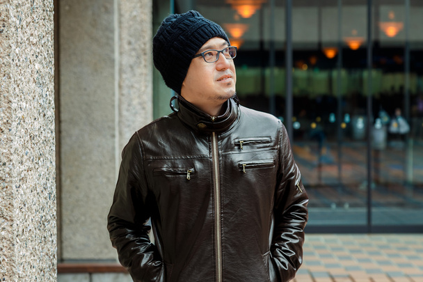 Un hombre asiático en una chaqueta marrón
  - Foto, Imagen