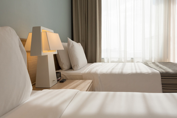 Camera da letto con cuscini bianchi, lenzuola e tenda
 - Foto, immagini