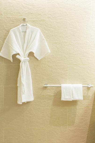 Vestido de ducha blanco y toallas pequeñas
  - Foto, imagen