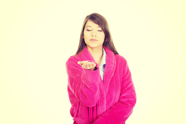 Woman in pink bathrobe showing empty palm. - Photo, Image