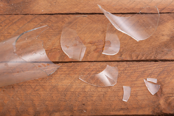 Κομμάτια του σπασμένου γυαλιού σε ξύλινα φόντο - Φωτογραφία, εικόνα