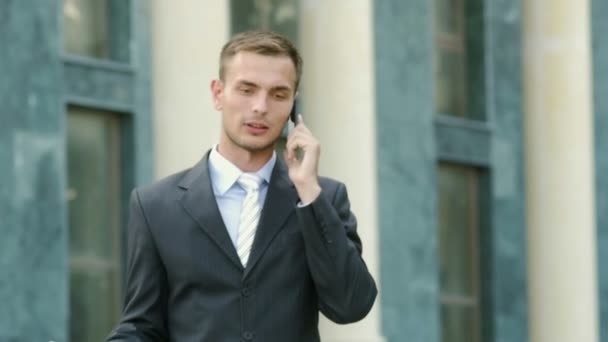 businessman talking on the phone walking - Video