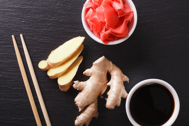 soy sauce and pickled ginger on a board. Horizontal top view clo - Fotó, kép