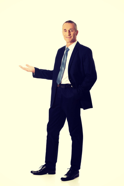 Businessman holding something on his palm - Foto, Bild