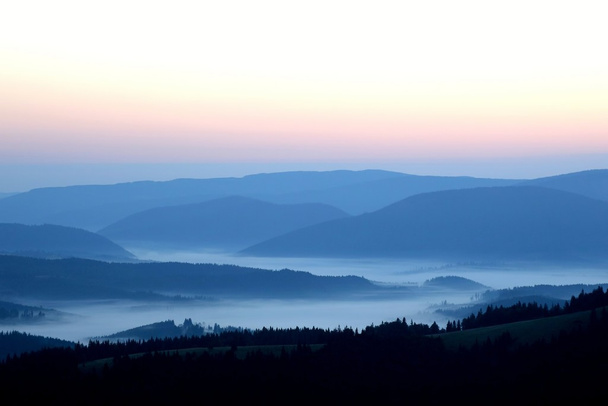 vuoret usvassa ennen auringonnousua
 - Valokuva, kuva