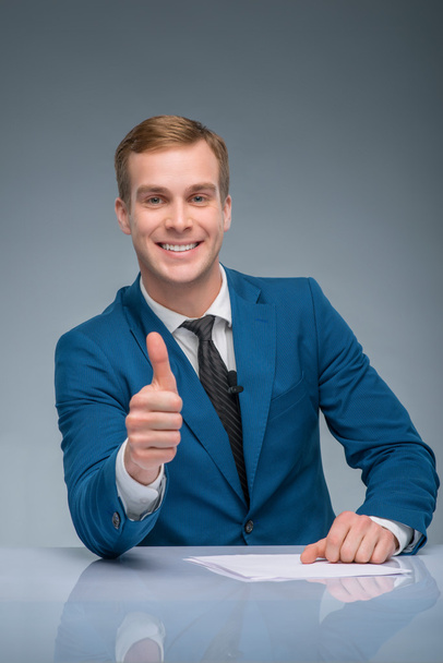 Smiling newscaster showing thumbs up. - Foto, Bild
