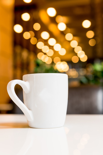 Valkoinen kahvikuppi kahvilassa
  - Valokuva, kuva