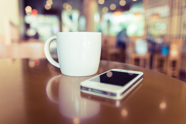 filiżanka kawy biały w kawiarni z telefonu komórkowego - Zdjęcie, obraz