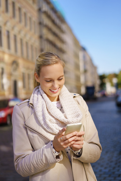 modische Frau mit ihrem Handy auf der Straße - Foto, Bild