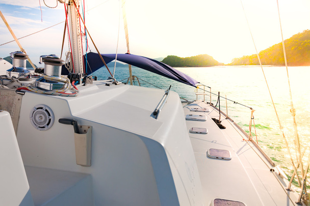Catamarano yacht a vela per una piccola isola durante il tempo del tramonto
 - Foto, immagini
