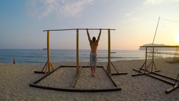 Hombre mostrando una fuerza impresionante, haciendo un músculo en la playa
 - Metraje, vídeo