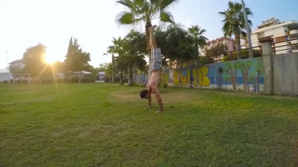 Hombre mostrando una fuerza impresionante, haciendo un soporte de mano en un parque
 - Metraje, vídeo