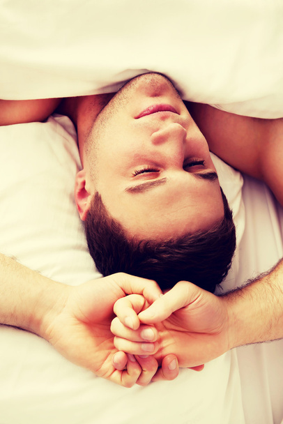 Handsome young man lying in bed. - Fotó, kép
