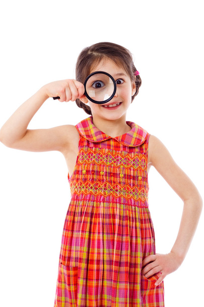 Girl looking through a magnifying glass - Φωτογραφία, εικόνα
