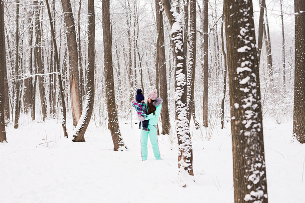 Szczęśliwa rodzina matka i córka dziecko na zimowy spacer w lesie - Zdjęcie, obraz