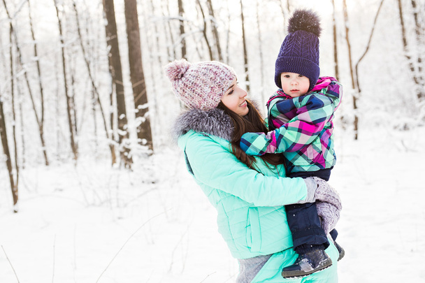 feliz familia madre e hijo bebé hija en un paseo de invierno en el bosque
 - Foto, imagen