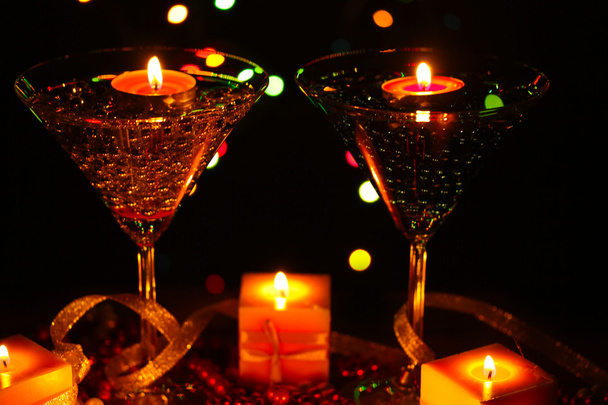 Amazing composition of candles and glasses on wooden table close-up on bright background - Zdjęcie, obraz