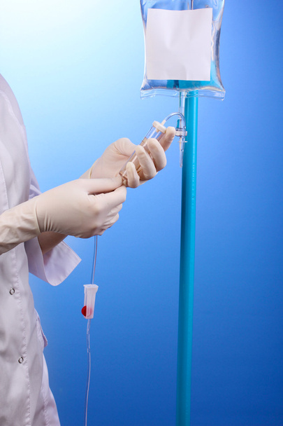 Nurse doing infusion on blue background - Photo, Image