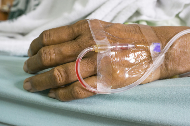 Hand of a old women patient with saline intravenous (IV) drip in - Photo, Image