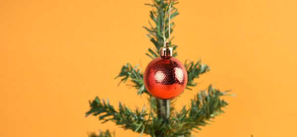 geschmückter Weihnachtsbaum mit bunten Ornamenten auf gelbem Hintergrund - Foto, Bild