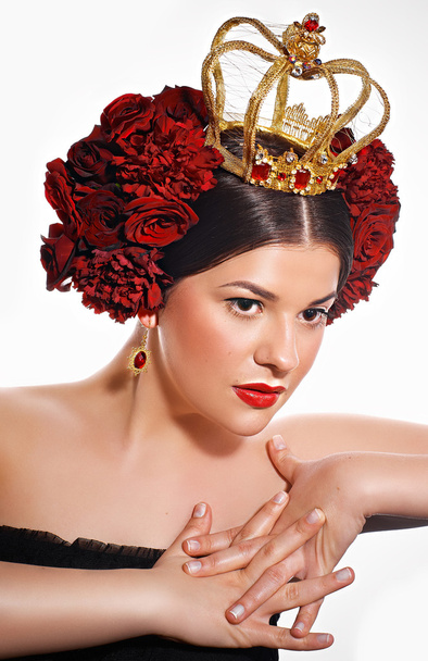 Portrait of brunette with red roses in her hair and a crown - Fotoğraf, Görsel