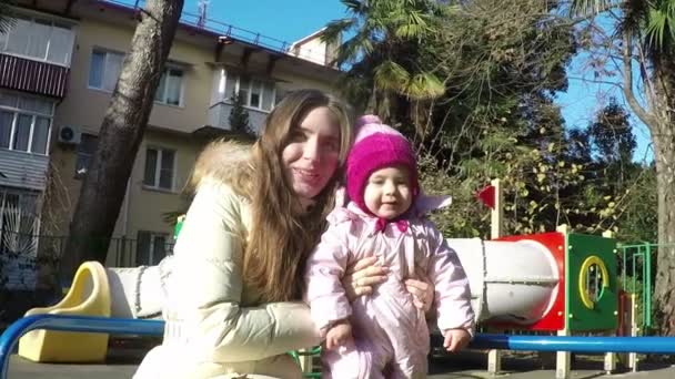 Anne ve kızı sonbahar güneşli günü parkta bir salıncak üzerinde. ağır çekim. Full Hd - Video, Çekim