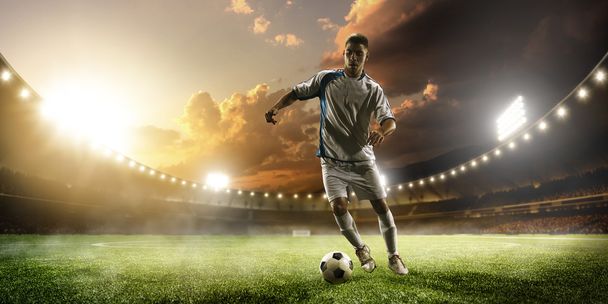 Soccer player in action on sunset stadium panorama background - Foto, afbeelding