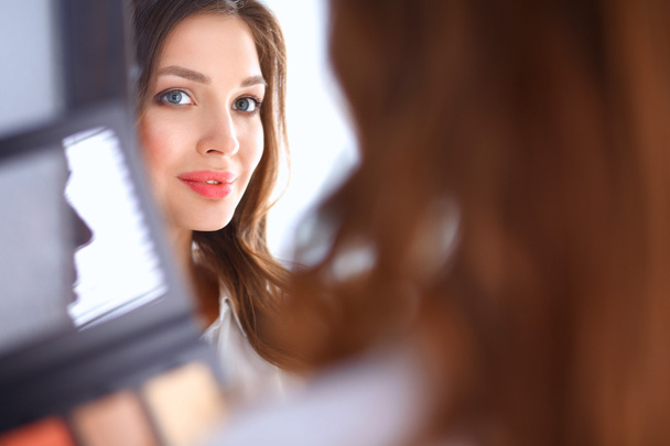 Young beautiful woman making make-up near mirror - Fotoğraf, Görsel