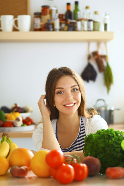 Young woman sitting near desk in the kitchen - Photo, image