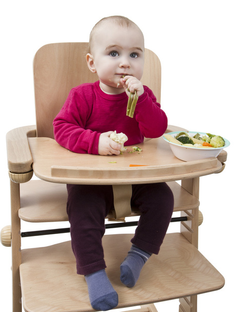 Niño pequeño comiendo en silla alta
 - Foto, imagen