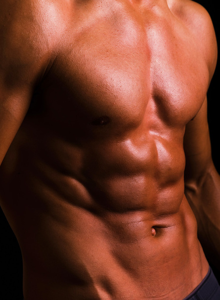 Torso of an athletic man on black background - Foto, immagini
