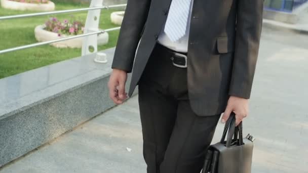 businessman in a suit comes along office building - Séquence, vidéo