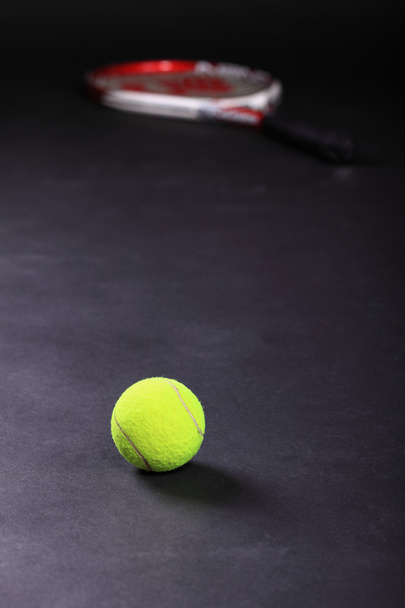 Tennis racket and balls on black background - Foto, afbeelding