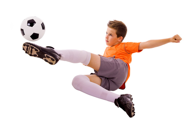 Young boy with soccer ball doing flying kick, isolated on white - Foto, Bild
